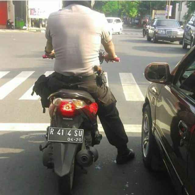 Sepeda motor berplat R dengan nomor yang tidak biasa terlihat di perempatan depan Polres Banjarnegara. Uniknya sang pengendara berseragam polisi. (Istimewa)