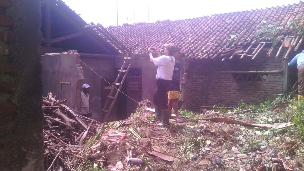 Sejumlah warga di Majenang Kabupaten Cilacap tengah bekerja bakti memperbaiki rumah yang rusak akibat longsor. (Foto: Purwokertokita.com/Ridlo)