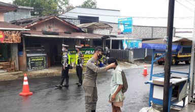 Petugas tim gabungan Satpol PP dan TNI-Polri serta Satgas COVID-19 Kecamatan Watumalang memakaikan masker ke seorang anak pada operasi penegakan protokol kesehatan (Prokes) di kawasan Pasar Desa Gondang pada Senin (5/10/2020)